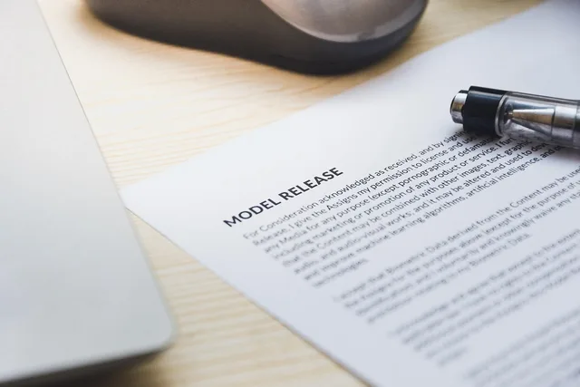 paper, model release, form, document, signing, pen, desk, agreement, business, contract, signature. Creator collaboration problems: rights and image use